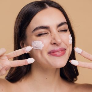 Femeie aplica un produs cu SPF 50