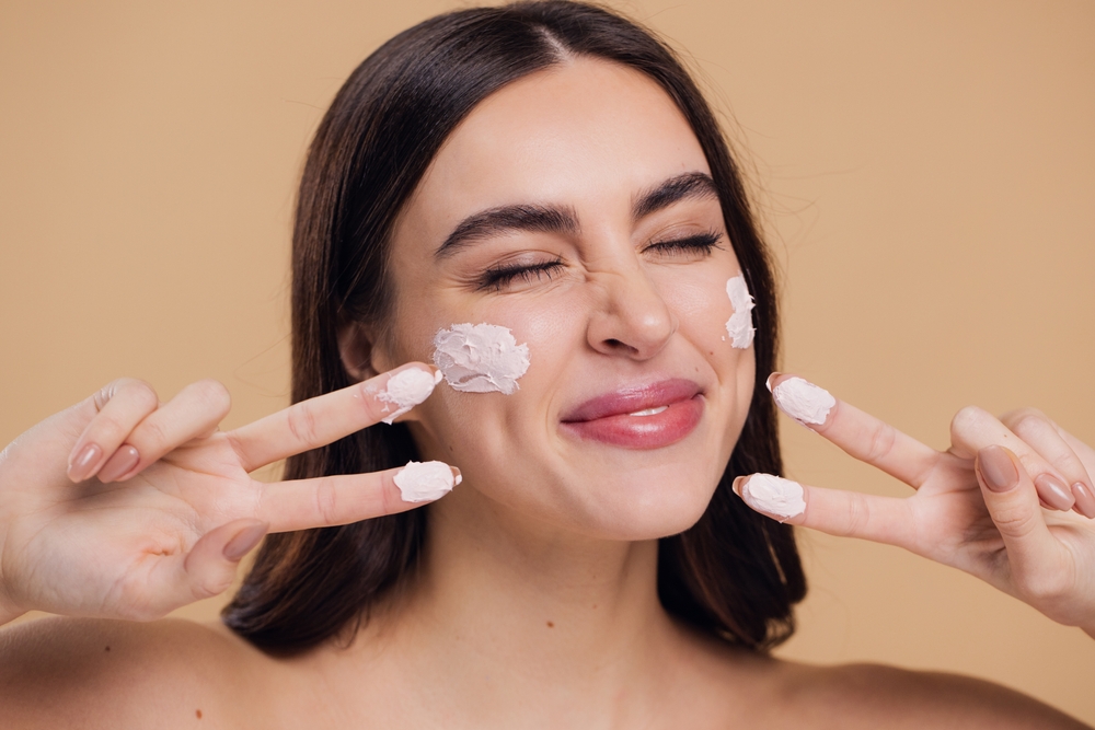 Femeie aplica un produs cu SPF 50